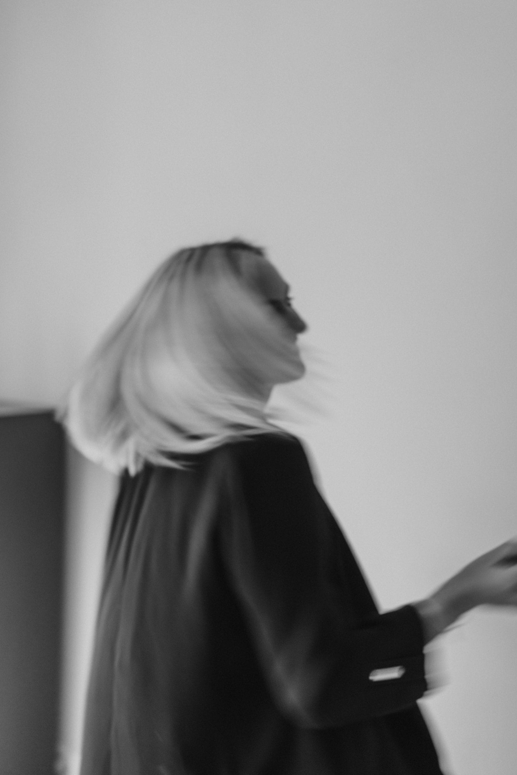 Eine lächelnde Frau dreht sich und ihre Haare schwingen dabei mit.